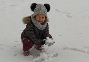 Dziewczynka lepi ze śniegu